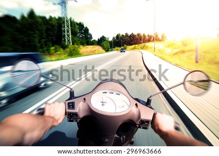 Man riding scooter on an asphalt road - person of view perspective
