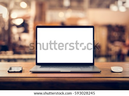Laptop with blank screen on table in industrial interior