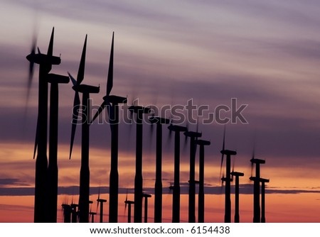 Windmills with turning blades at sunset in eastern Washington