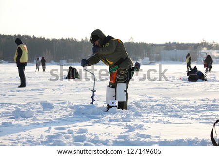 MOSCOW, RUSSIA - FEBRUARY 3: Fisherman does hole during the annual competition ice fishing, fishing on fishing tackle (mormyshka), February 3, 2013 in Moscow, Russia.