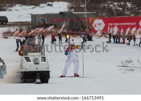 Novosibirsk, Russia - December 7, 2013 :Man climbs on skis with the Olympic torch for the Olympic torch relay in Novosibirsk