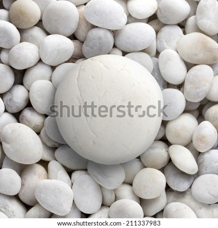 Big white stone laid on a pile of small round circle shape pebble, a group of rocks. can use for background or texture