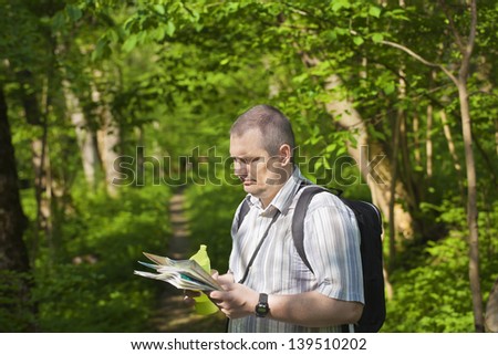 Hiker explores the map in the woods on trails