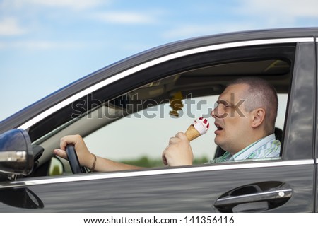Man eating ice cream while sitting in car