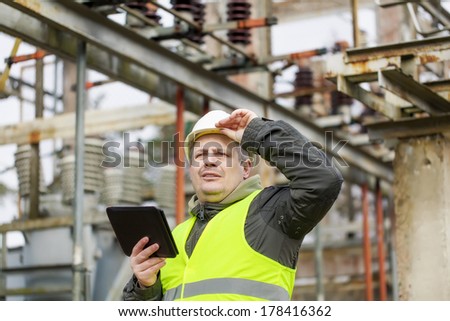 Electrical Engineer with tablet PC in electrical substation
