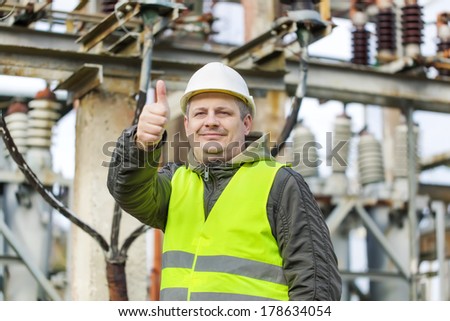 Electrician in electrical substation near to high-voltage cable