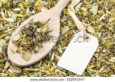 Curative natural herbal tea with hang tag on wooden spoon