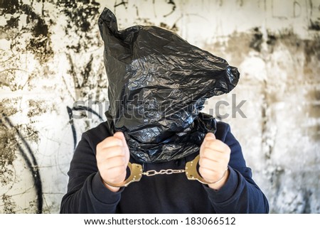 Hostage in handcuffs and with a bag on head