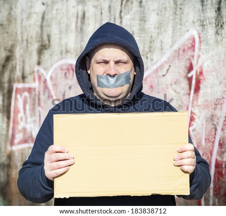 Demonstrator with a tape on a mouth and poster in hands