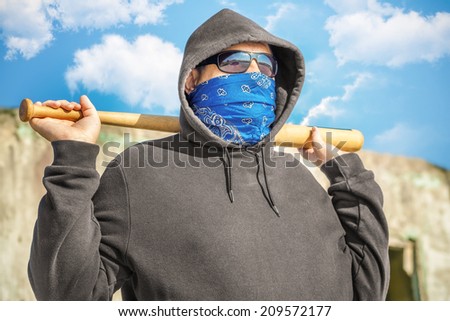 Man with a baseball bat on blue sky background