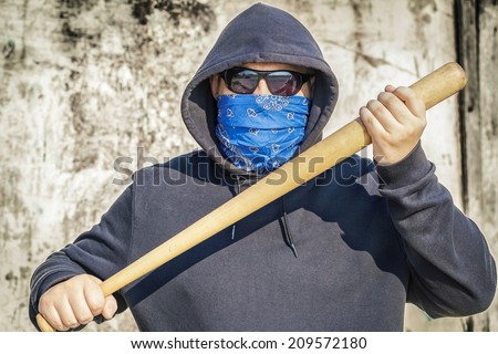 Man with a baseball bat on old wall background