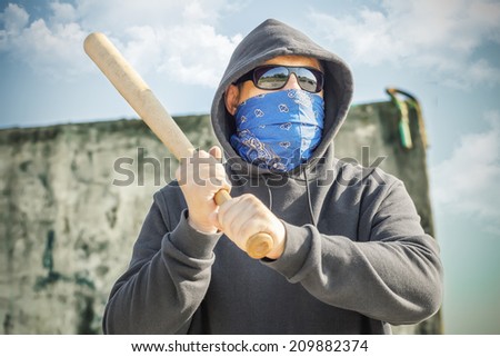 Man with a baseball bat at outdoor near wall