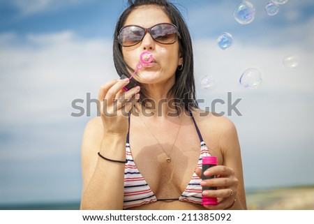 Woman blowing bubbles at the sea
