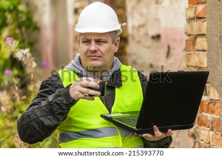 Construction Engineer working with PC and drinking tea