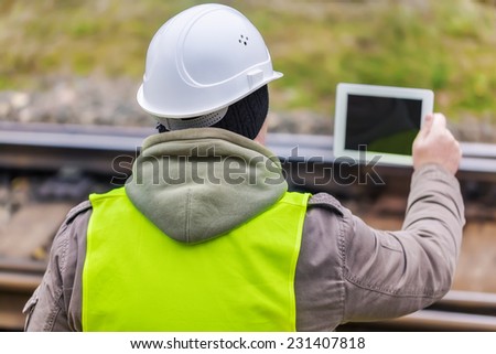 Railway engineer with tablet PC on rails