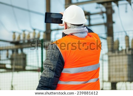 Electrical Engineer with tablet PC in the electric substation