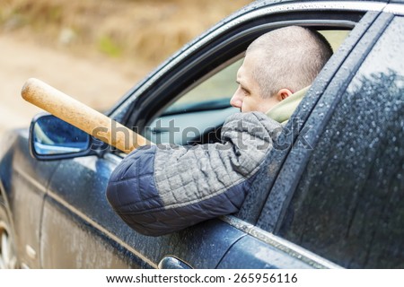 Aggressive man with a baseball bat in car