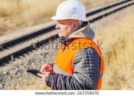 Railway Engineer with tablet PC near to railway