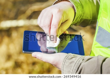 Close up of man hand with wipe on tablet PC