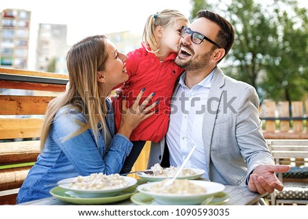 Happy family is enjoying pasta in restaurant.