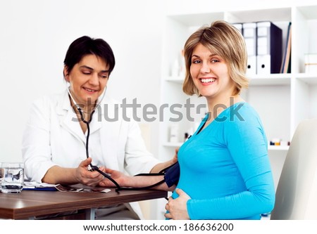 Pregnant woman in the doctor\'s office. She has a prenatal check up.