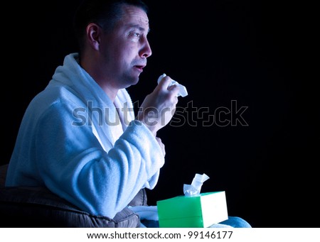 crying  Caucasian man with a tissue watching a movie on television