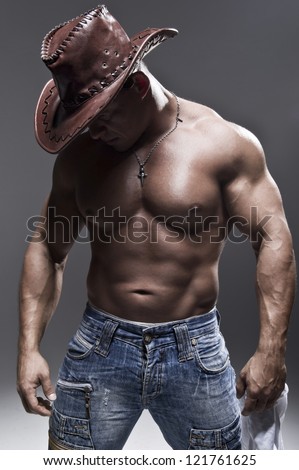 A muscular man in a cowboy hat