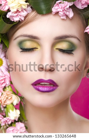 beauty woman portrait with wreath from flowers on head pink back