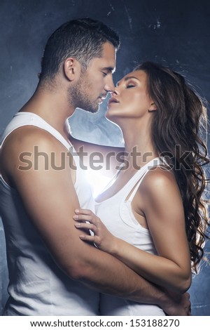 Beautiful Young Smiling Couple In Love Embracing Kissing