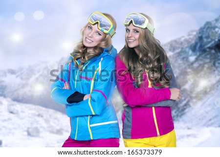Two beauty smiling women in winter in mountains