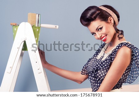 Beauty pinup girl with equipment for painting
