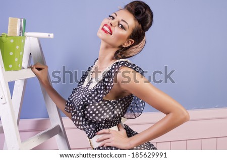 Beauty pinup girl with equipment for painting