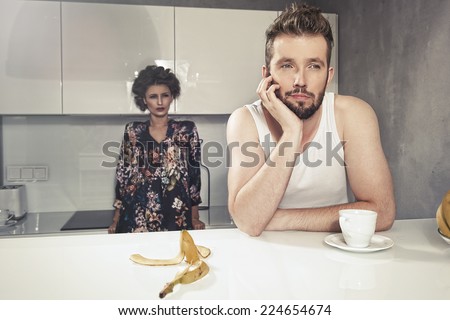 Funny couple after breakfast. Strange faces. Young man and beauty woman in kitchen