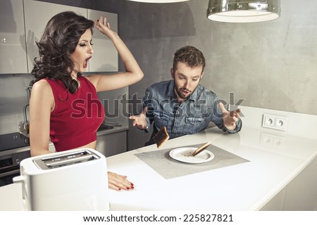 Funny couple after breakfast. Strange faces. Young man and beauty woman in kitchen