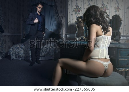 Sexy couple in bedroom. Man drinking