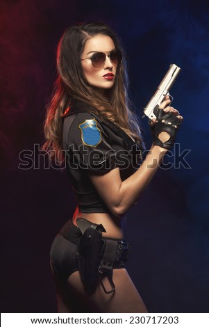 Sexy woman with police uniform in studio on dark red and blue background