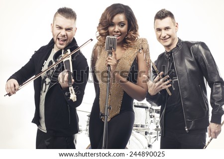 Fashionable music band posing on white background. Two handsome man and beautiful sexy woman with music instruments