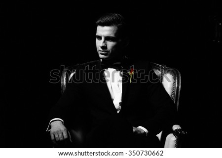 Portrait of man who sitting on chair, godfather-like character.