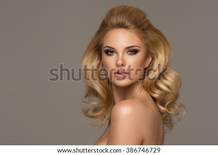 Sensual beautiful blonde woman posing. Girl with long curly hair.