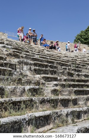 DENIZLI, TURKEY - May 21, 2013. Tourists visit amphitheatre of Hierapolis in Denizli, Turkey on 21 May 2013. Hierapolis was an ancient Greco-Roman city in Phrygia.