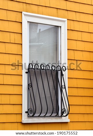 Window exterior, white frame, orange wall, black metal grate