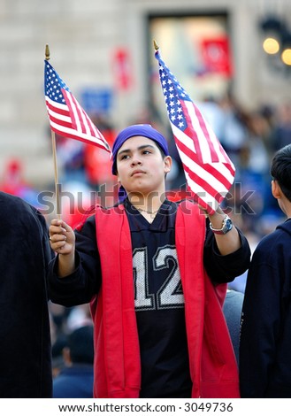 Latino boy holding American flags at pro immigration rally in Boston, Massachusetts. April 10, 2006.