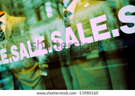 Sale sign on glass window of fashion boutique