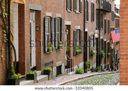Acorn Street in Beacon Hill, Boston. Brick apartment facades, flower pots framing house entrance, window box, lamps and cobblestone way. Tourist attraction, historic landmark, nice place to walk by.