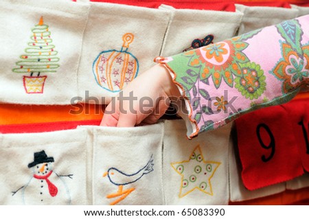 Advent Calendar Girls on Little Girl Hand Reaching Into Pocket Of Advent Christmas Calendar