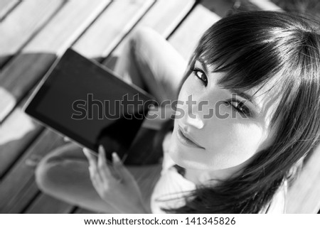 Beautiful Caucasian Student Sitting Down Using A Digital Table And Or E-reader.