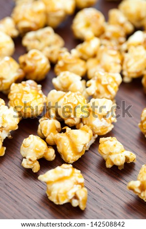 Macro Photo Of Caramel Popcorn Dispersed On Table.