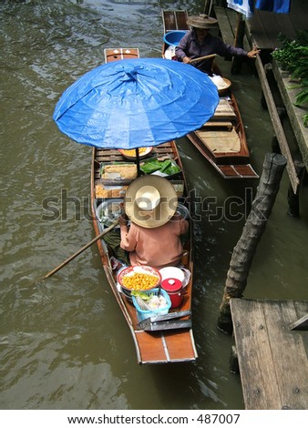 Woman selling foods on a floating market in Thailand - Damnoen Saduak Floating Market, neer bangok
