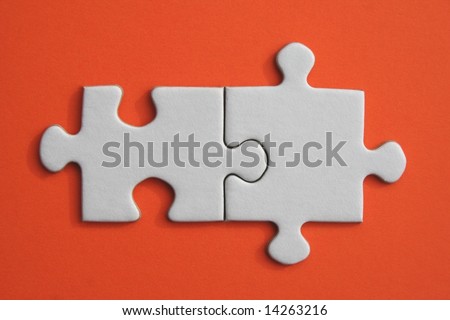 White jigsaw pieces on orange paper background