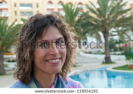 Young woman is situated against the prestige resort background. She is glad.